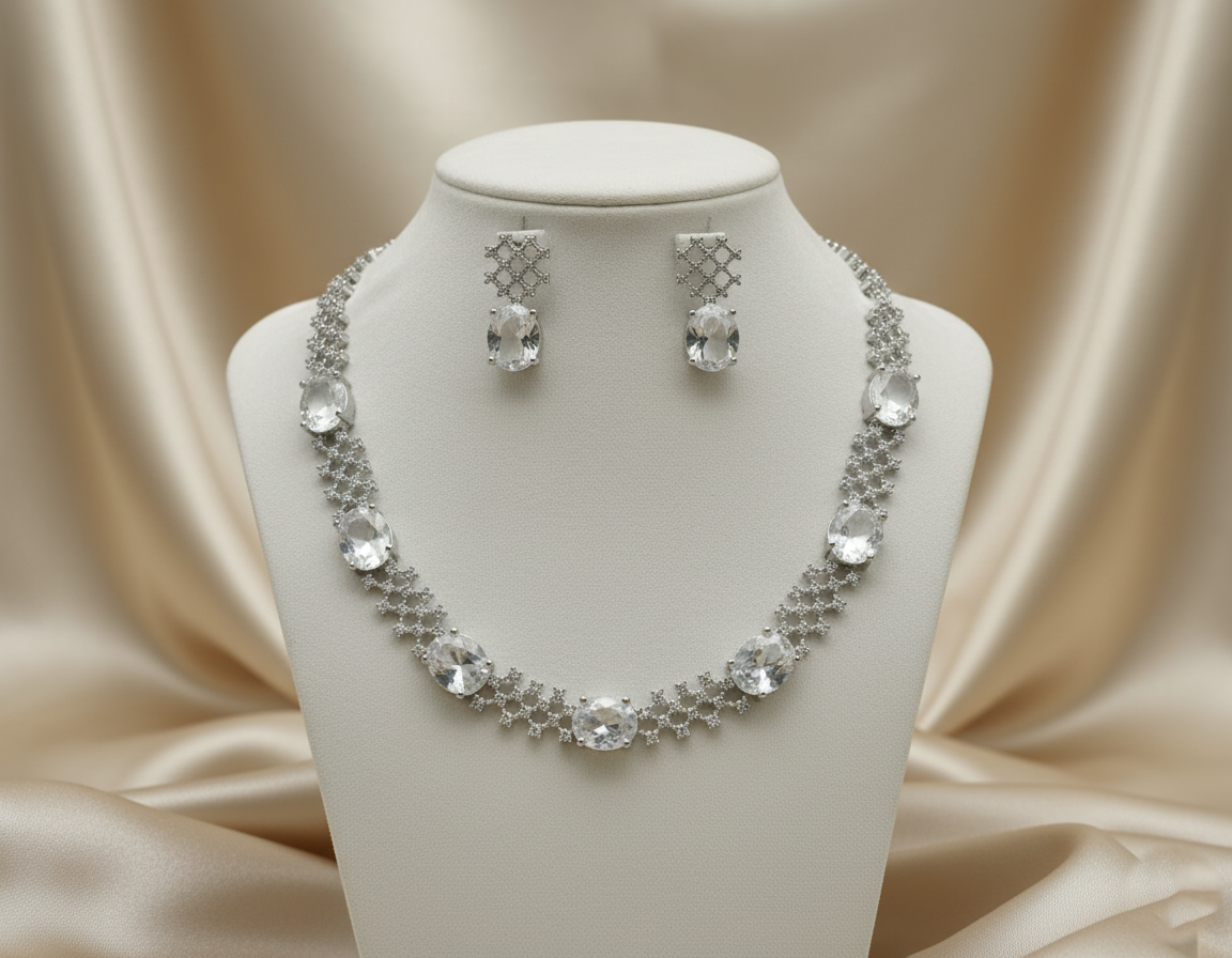 Silver necklace and earrings set on a mannequin bust with a beige fabric background