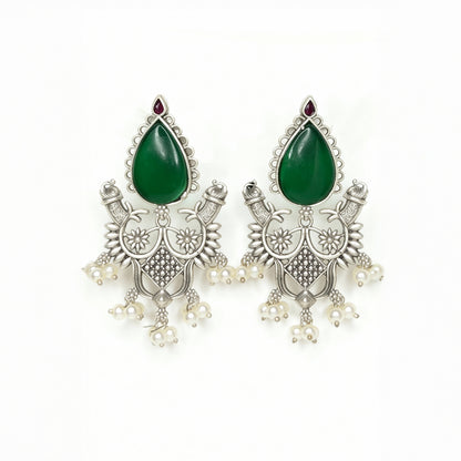 Pair of silver earrings with green teardrop stones on a white background