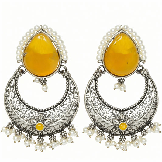 Pair of earrings with yellow teardrop stones and silver floral designs on a white background