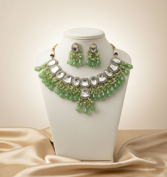Green and silver jewelry set on a white mannequin bust with a beige background