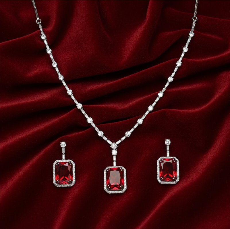 Jewelry set with red gemstones on a red fabric background