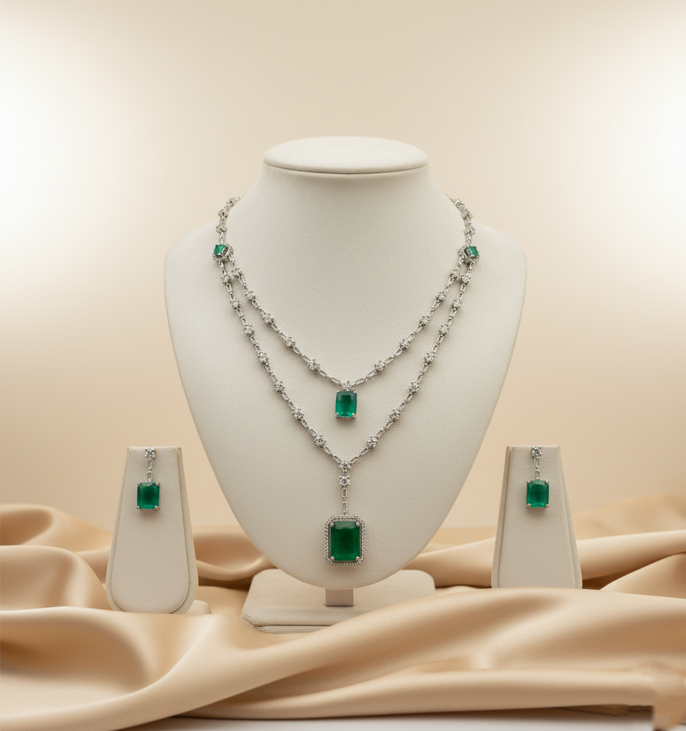 Emerald and diamond jewelry set on a mannequin bust with a beige fabric background