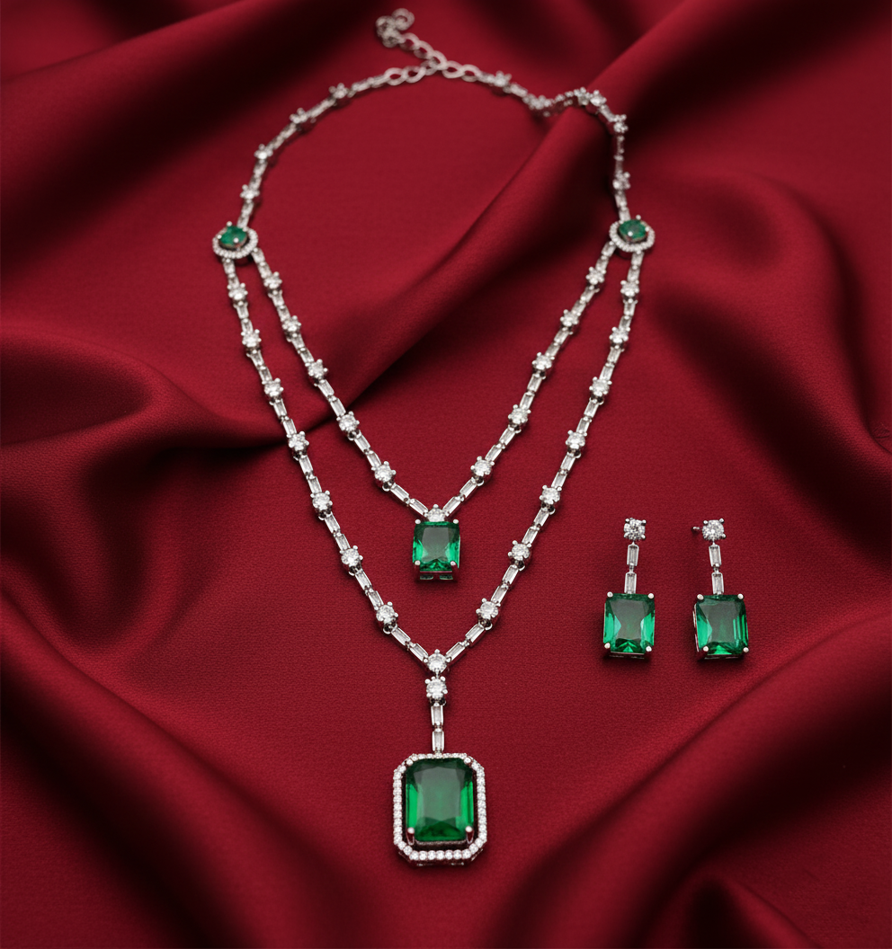 Emerald and diamond jewelry set on a red fabric background