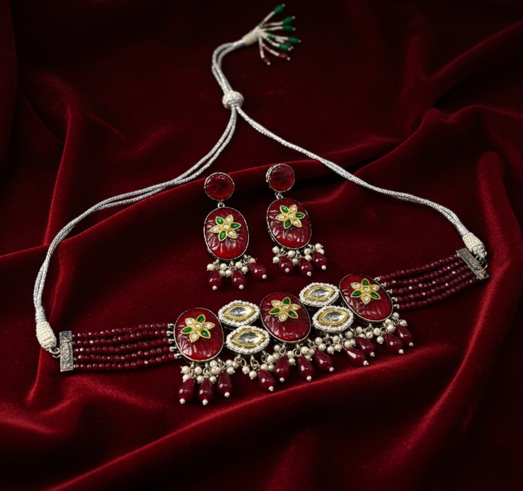 Jewelry set with necklace, earrings, and bracelet on a red fabric background