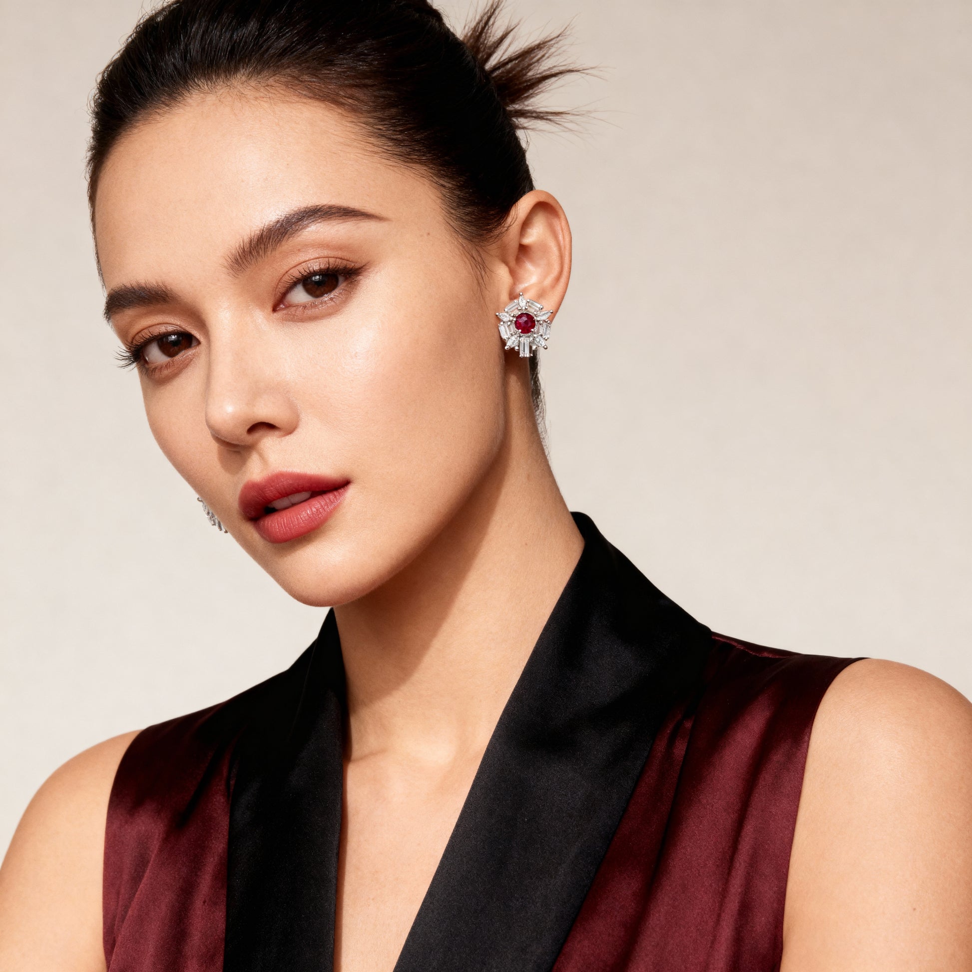 Woman wearing a pair of earrings with a neutral background