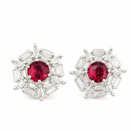 Pair of earrings with red gemstones and silver accents on a white background