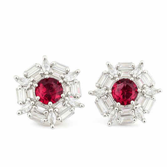 Pair of earrings with red gemstones and silver accents on a white background